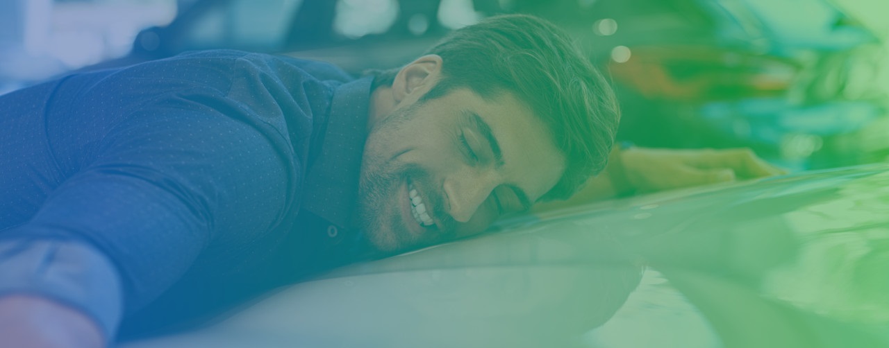 Glad mand krammer kølerhjelmen på en bil