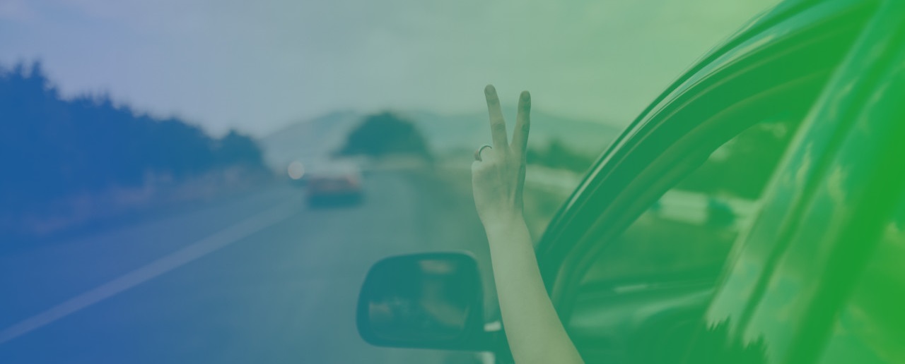Peace tegn med venstre hånd ud af vinduet på en kørende bil
